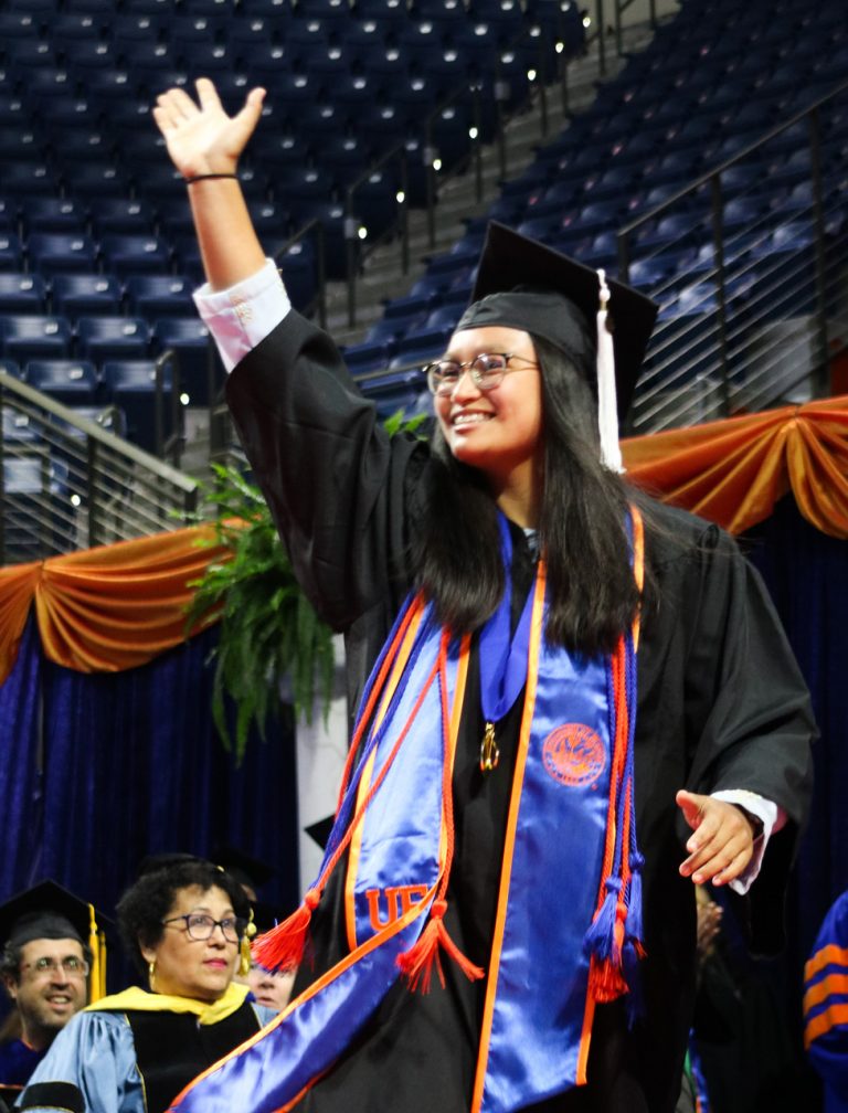 Graduating student waving to the crowd