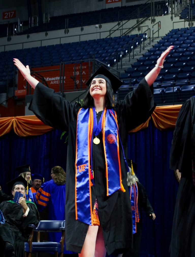 Graduating student with both arms in the air