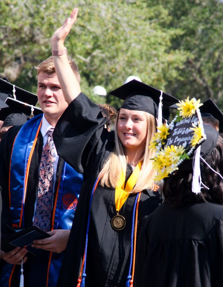 Graduating student waving at someone