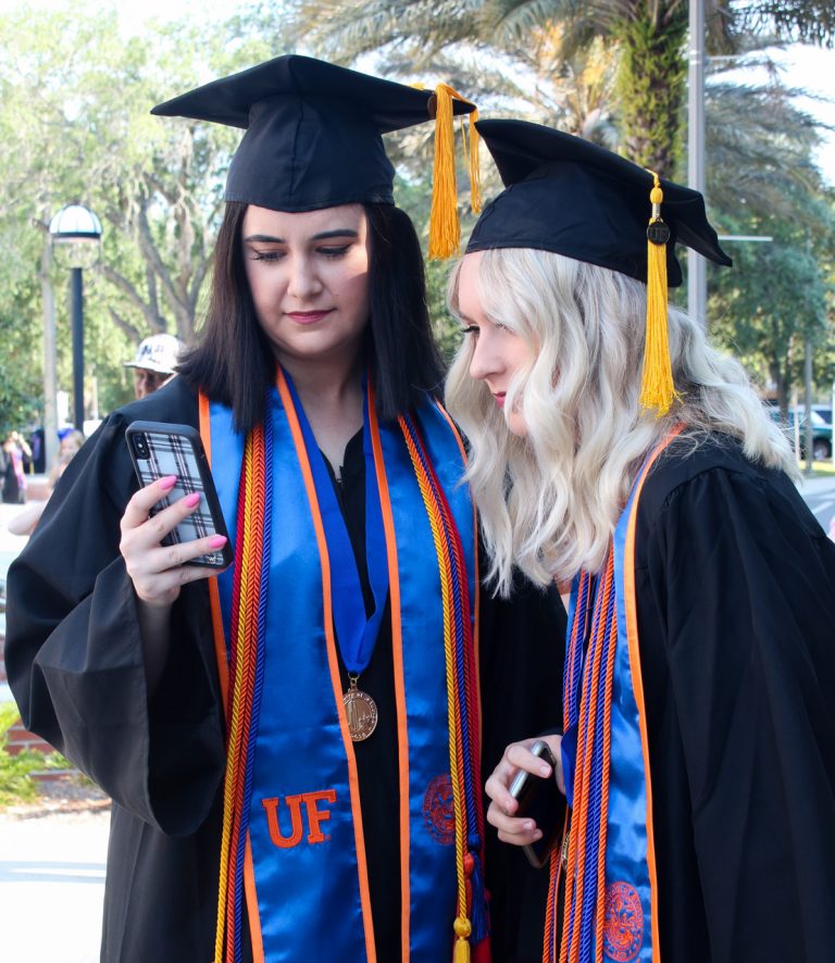 Graduating students looking at phone
