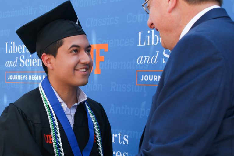 Graduating student shaking hands with President Fuchs