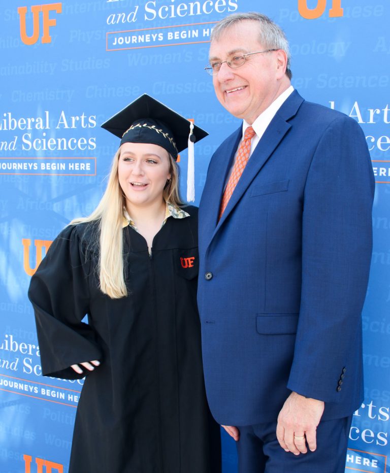 Graduating student and President Fuchs pose for a picture