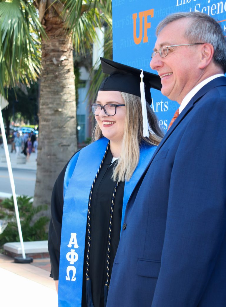 President Fuchs and graduating student pose for picture