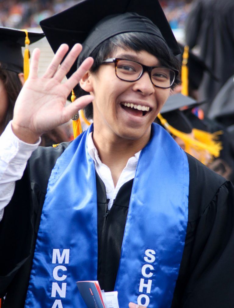 Graduating student waving at camera