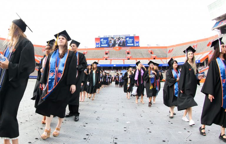 Group of graduating students walking into stadium