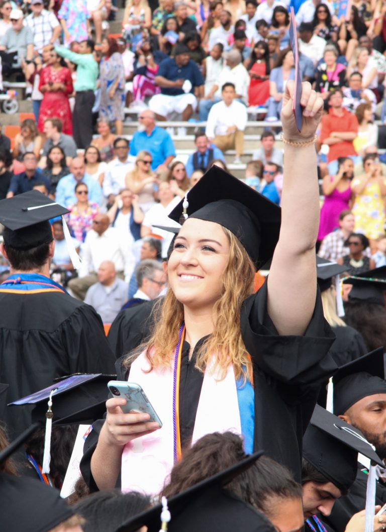 Graduating student waving at the crowd